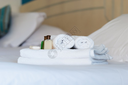 白色纯底素材旅馆床上的白色纯毛巾温泉打扫洗涤游客淋浴奢华身体折叠团体房间背景