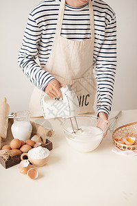 用搅拌机和烘烤蛋糕混合碗中的白蛋奶油白色酥皮鞭打面团男人烹饪玻璃桌子厨房食谱背景图片