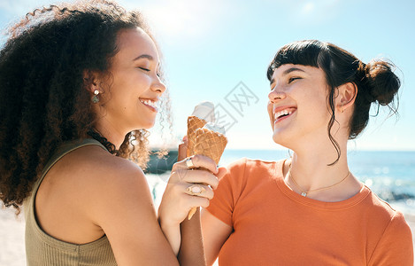 吃得少两个迷人的年轻女友在海滩上吃冰淇淋 玩得开心极了 你觉得呢? - 是的背景