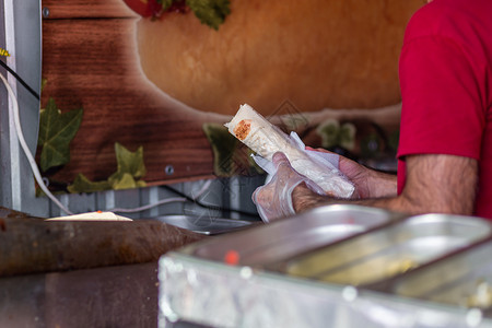一位专业厨师的手 他制造Shawarma手套烹饪桌子面包火鸡小吃陀螺仪餐厅男性捐赠者背景图片
