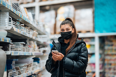 在病毒流行期间 戴面罩买东西的女人口罩疾病店铺全世界技术成人购物阅读面具防护背景图片