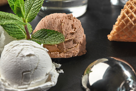 卖冰淇淋蛋奶油和巧克力冰淇淋 在黑色背景的一块石板上卖榛子食物奶制品美食服务牛奶坚果锥体桌子胡扯背景
