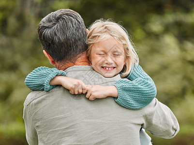 拥抱父亲孩子爸爸的拥抱是最好的 父亲和他年轻的女儿在户外度过时光背景