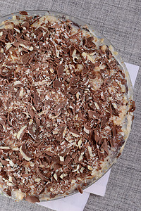在家蛋糕上做的蛋糕 巧克力粉牛奶食物芯片餐巾白色背景图片