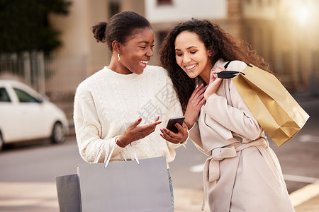 新店警讯 两名年轻女性使用智能手机 在城市背景下买东西时使用智能手机背景图片