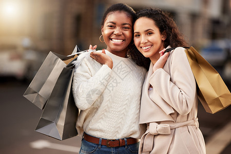 多棒的周六度假方式啊 两个年轻女人在城市背景下购物的肖像 (笑声)背景图片