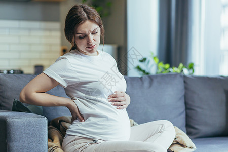 孕妇抽筋感觉不舒服 怀孕的孕妇抱着肚子 感到不适 疼痛背景