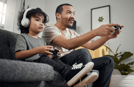 一个可爱的小男孩 和他父亲在家玩电子游戏 他老爸完全不知道他会输掉这个小男孩背景