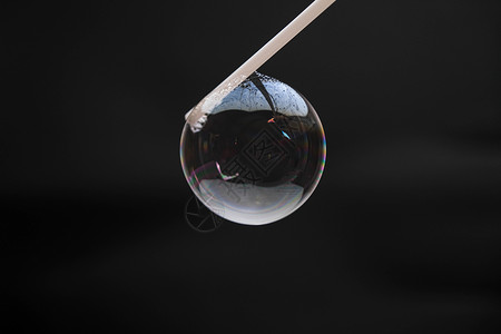 美丽的肥皂泡沫在黑色背景上被一根稻草吹散 而抽象肥皂泡沫则带有多彩的反射环形圆圈漂浮环境想像力坡度彩虹液体运动乐趣背景图片