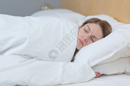 一个睡不着 心烦意乱的女人 躺在床上 躺在毯子下 想睡觉的照片思维苏醒女士音乐孤独卧室疾病恶梦说谎疼痛背景图片