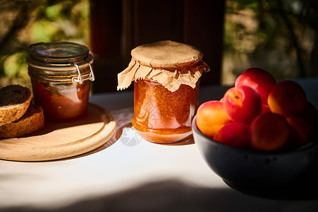 一杯自制果酱 美味的成熟红杏子 在老生常谈的夏日厨房桌子上的蓝陶瓷碗里背景