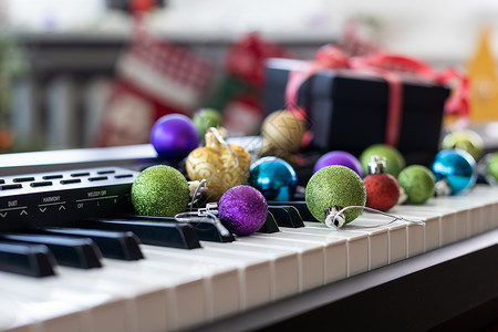 音乐合成器上的新年作曲 花环的灯 快乐圣诞贺卡 新年快乐音乐会歌曲玩具乐器浆果自行车钢琴娱乐键盘静物背景图片