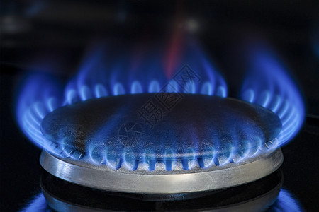 燃烧天然气 丙烷 在黑色背景上的煤气炉 带有蓝色火焰的燃气厨房炉灶的碎片 特写 能源危机概念 价格上涨或天然气价格上涨灶台宏观器背景图片