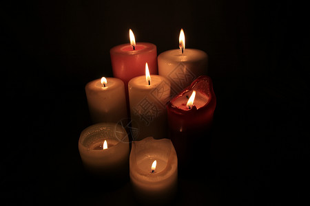 以不同高度和颜色燃烧的蜡烛群烛光悲伤教会精神仪式信仰宗教团体火焰烧伤背景图片