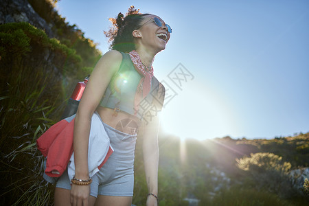 我没想到日落会变漂亮了 一个年轻女人在远足时 戴着墨镜穿着太阳镜呢背景图片