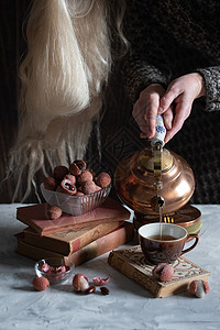 一个女人从铜茶壶里倒茶水 泡到杯子里 喝着莱奇和温柔的生活女性享受喝咖啡文化静物荔枝女士桌子注意力爱好背景图片