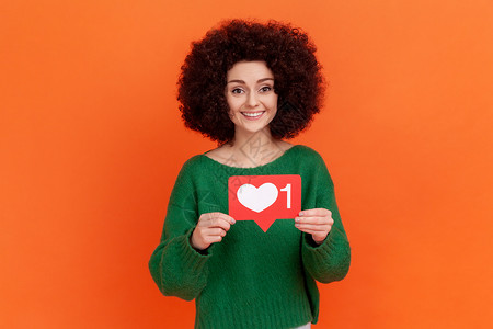 红色头图身穿绿色毛衣 站在社交媒体心胸如图标的非洲发型美容女性 建议跟随并热爱内容 ( un org)背景