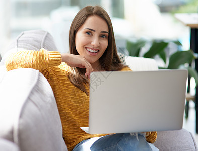 有了不封顶的wifi 家成了我最快乐的地方 一位年轻女子在家里的沙发上放松时使用笔记本电脑的画像背景图片