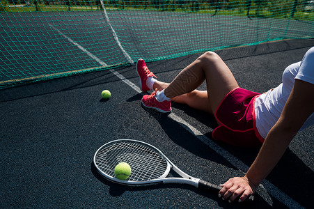 全钢无网一个穿着运动裙的无脸女孩坐在网球场上 拿着一枚火箭 对女性腿最有洞察力女士练习阳光娱乐网球锻炼橡皮运动员游戏运动鞋背景