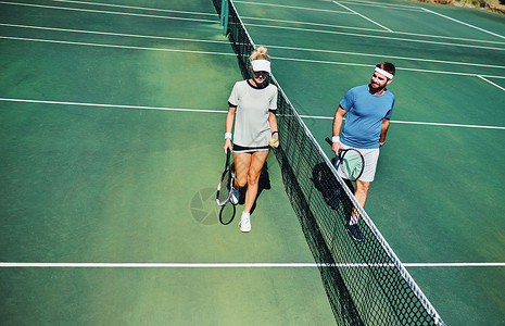 去哪网你支持哪一边 两名年轻网球运动员在网球场上一起在户外散步时交谈的全长镜头背景