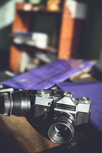 在木制桌子上用旧式的摄影机摄像头摄影案件古董技术相机相片镜片工作室历史框架背景图片