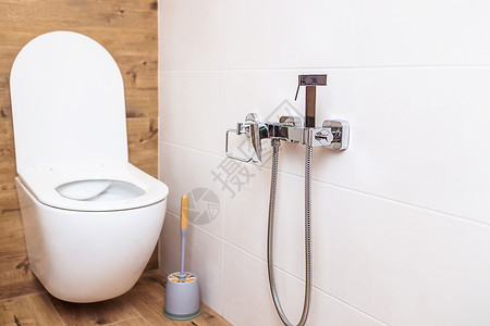 卫生室现代洗手间 特写白色马桶和墙上卫生淋浴背景