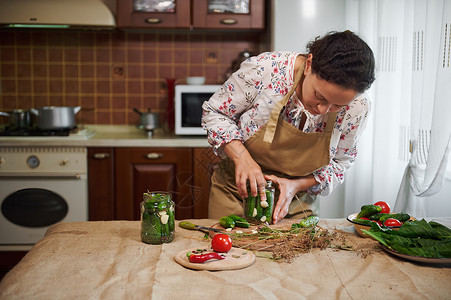 家庭主妇在家中厨房内为冬季准备自制泡菜 供冬用背景图片
