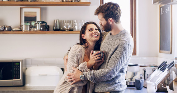 一对快乐的年轻夫妇在家厨房一起喝咖啡 享受咖啡时间会更好些 (笑声)背景图片