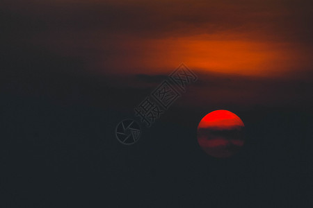 美丽的夕阳 太阳在日落时被云环绕 阳光照耀着振奋人心的橙色红云红太阳天空风景地平线石头黄色乌云橙子红色背景图片
