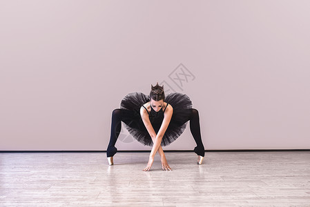 捣练图年轻芭蕾舞者在表演前练习 在黑色塔图 古典舞蹈演播室 影视空间上练过歌舞 并制作了背景