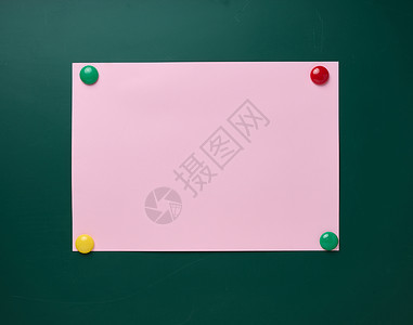 在绿色学校董事会上附有含有磁铁的空粉红色纸页背景