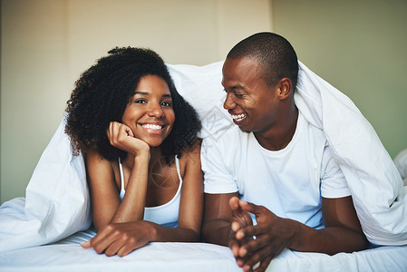 爱值得唤醒 一对快乐的年轻夫妇在卧房下放松的肖像背景图片