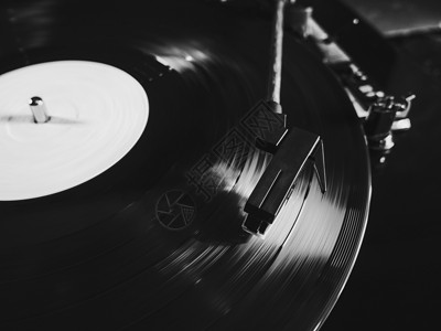 金曲读取 LP 转盘旋转的唱机或胶囊头 特写转盘乙烯基手写笔下降 在播放器上播放黑色 33 rpm 唱片的开头 黑与白背景