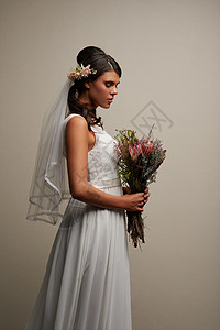 最美的新娘 一个年轻美丽的新娘在灰色背景下被演播室拍到的照片背景图片