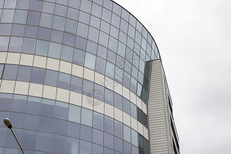高高现代大楼的镜像窗户墙壁摩天大楼蓝色办公室反射城市景观街道职场中心背景图片