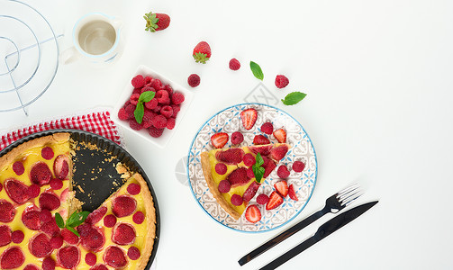 草莓蛋筒白桌上有红草莓和果的圆椰子蛋糕水果白色奶油甜点圆形食物绿色红色烹饪背景