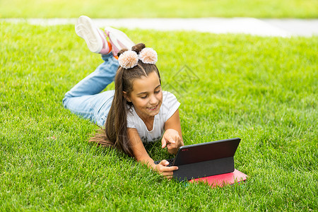 免费教育 业余时间 技术和互联网概念     有平板电脑的小女孩青少年冲浪耳机药片闲暇阅读学校青春期上网女孩背景图片