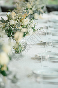 白色玻璃盘子餐厅的婚礼接待台装饰了白蜡烛和鲜花 并配有白色蜡烛和鲜花接待乡村桌子盘子银器玫瑰花束风格庆典色调背景