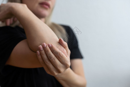 左环肌腱中年女人抱着她的手肘痛 所有的东西都孤立在白色背景上 您的文字空空位置是照片左半部疼痛雀斑疾病创伤女性手臂扭伤肌肉痛苦症状背景