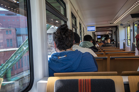 在德国的Wuppurtal悬浮电车中 乘客乘坐停运车辆旅行游客铁路城市火车自拍窗户民众女士微笑背景图片
