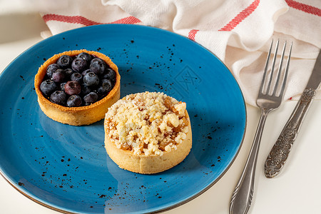 单粒蓝莓素材蓝莓和苹果派 放在蓝色瓷板上的鲜烤单部分蓝莓和苹果派糕点小吃水果面包甜点馅饼蛋糕糖果美食桌子背景