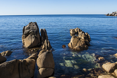 海中的岩石和清水绿色森林海洋石头溪流海岸旅行海滩瀑布背景图片