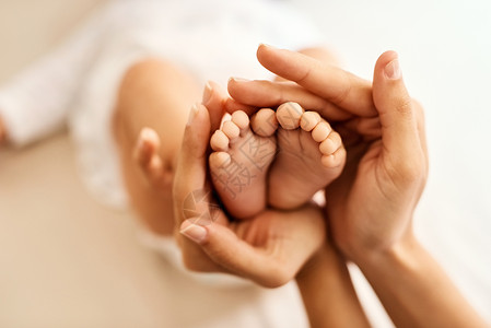 没有比小婴儿脚更甜的了 母亲轻轻地抱着她的婴儿脚背景图片