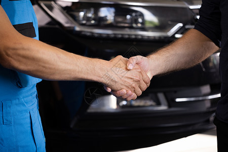 车损清单汽车修理工在车库里与客户握手 在机械车间工作的车辆服务经理 为客户检查和维护汽车发动机后取得成功 汽车修理背景