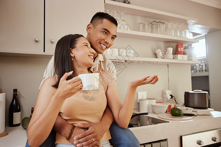 幸福 恩爱和浪漫的情侣在家里的厨房里结合 站立和拥抱 早上喝杯咖啡 夫妻谈天说地 深情相拥 享受无忧无虑的感觉背景