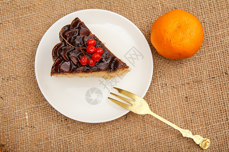 一堆水果和糕点巧克力蛋糕的切片 装饰着一堆肉桂 叉子和橙子背景