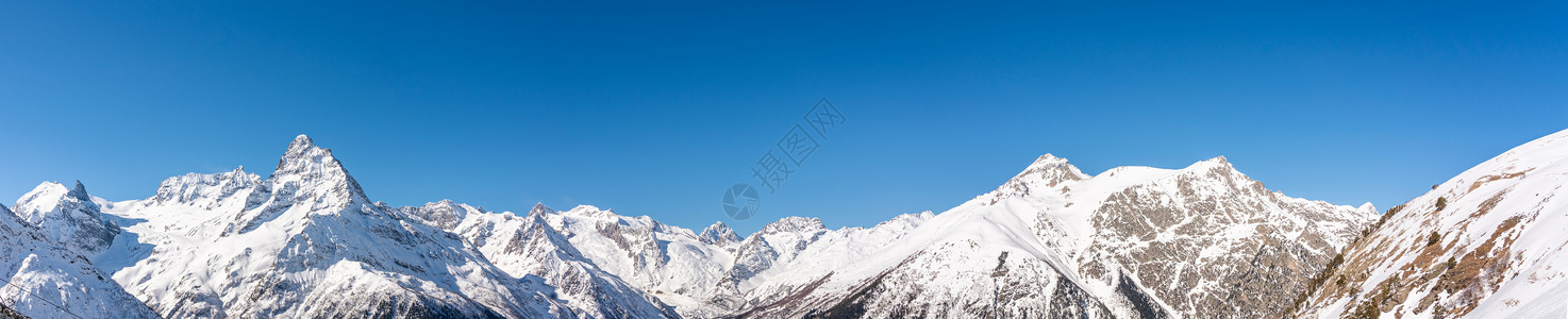 俄罗斯高加索地区蓝色天空的冬季雪山 风景全天观 俄罗斯晴天岩石顶峰山脉天际山链高山山峰地平线全景背景