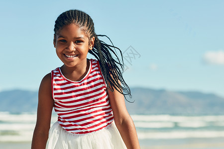 一个可爱的小女孩在海滩上玩得开心的肖像 她是个很可爱的小姑娘背景图片