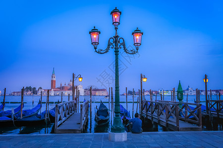 圣乔治马焦雷在意大利伊蒂亚尔威尼斯大运河上 由木系吊杆对接的冈多尔日落摄影路灯旅行码头优雅景观文化天空地方背景