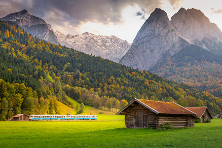 拉林铁路秋季巴伐利亚阿尔卑斯火车和日落木谷仓 德国加米施摄影阳光松树林巅峰目的地草地文化风景朝霞铁路背景